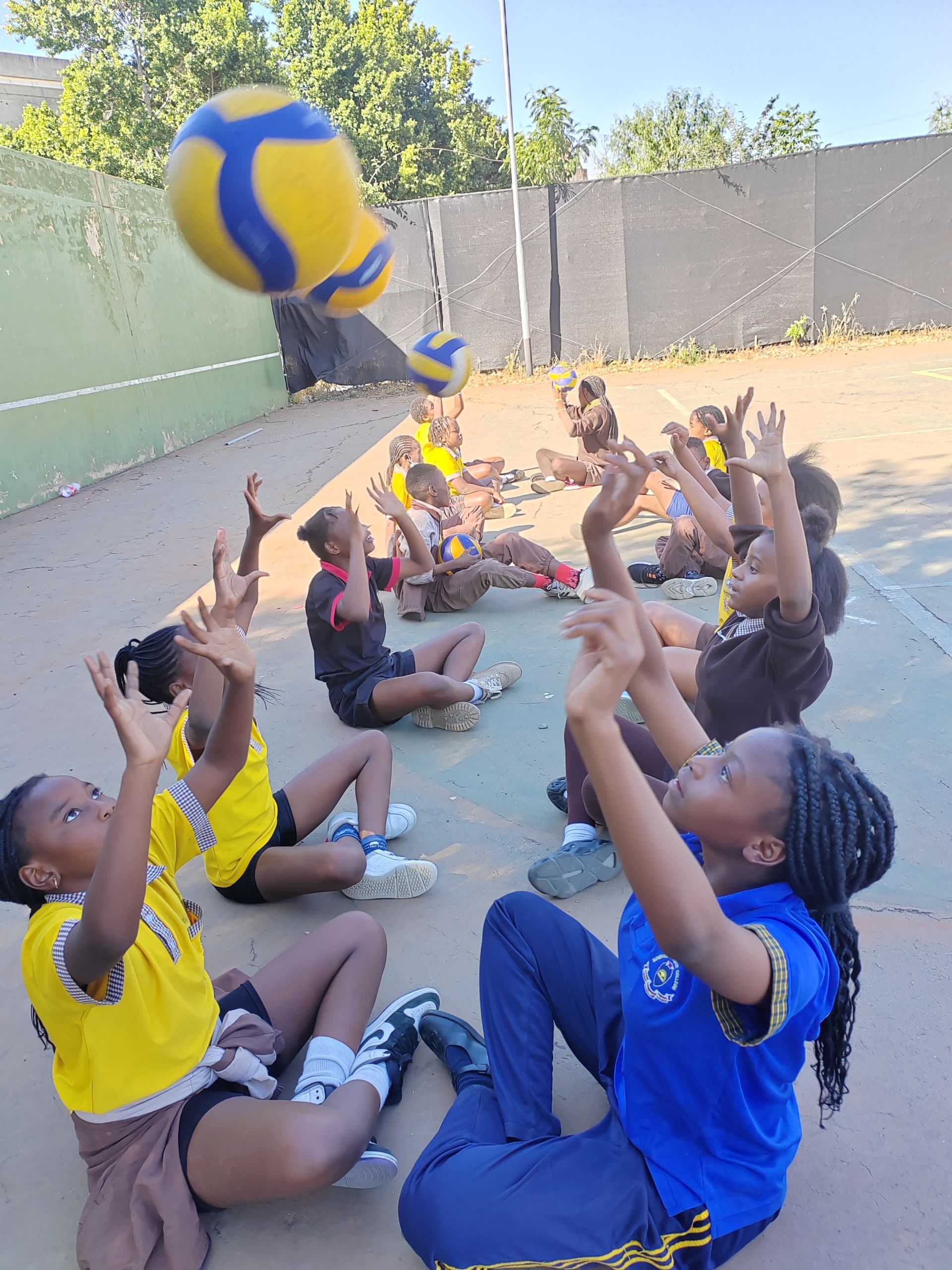 Volleyball players reaching up toward a ball