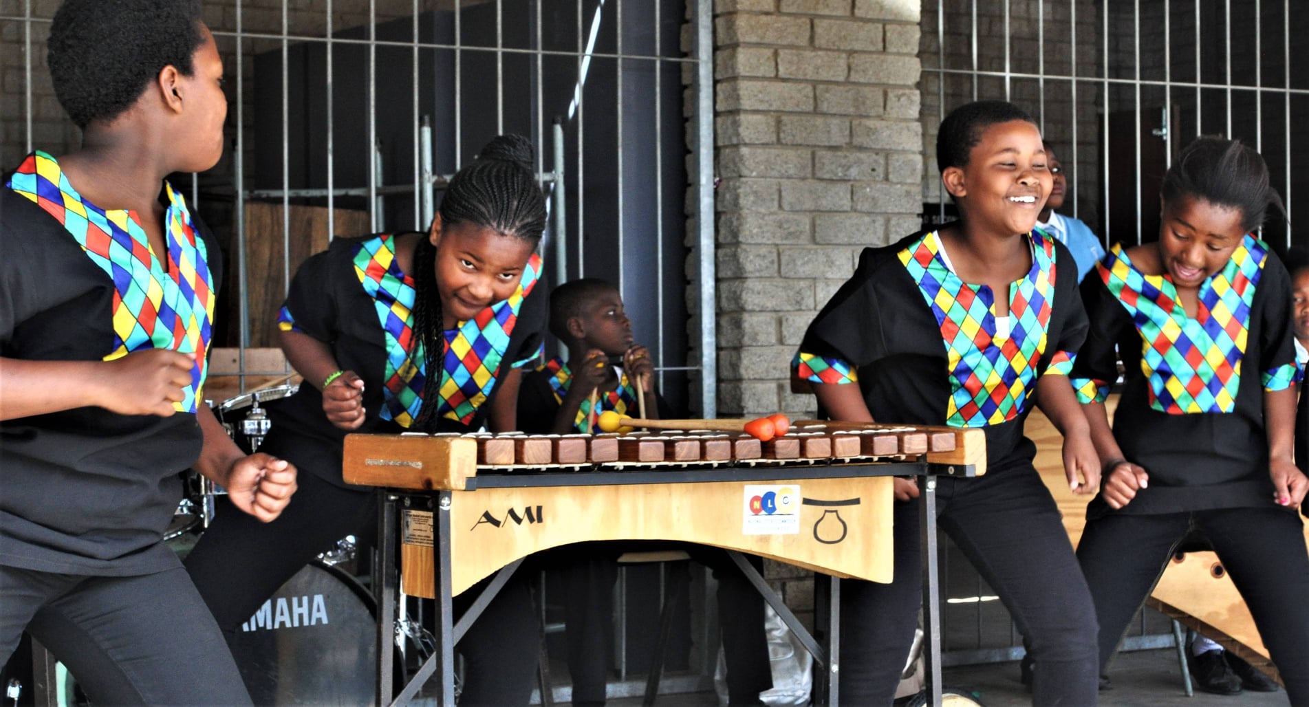 School musicians smiling while performing on marimbas