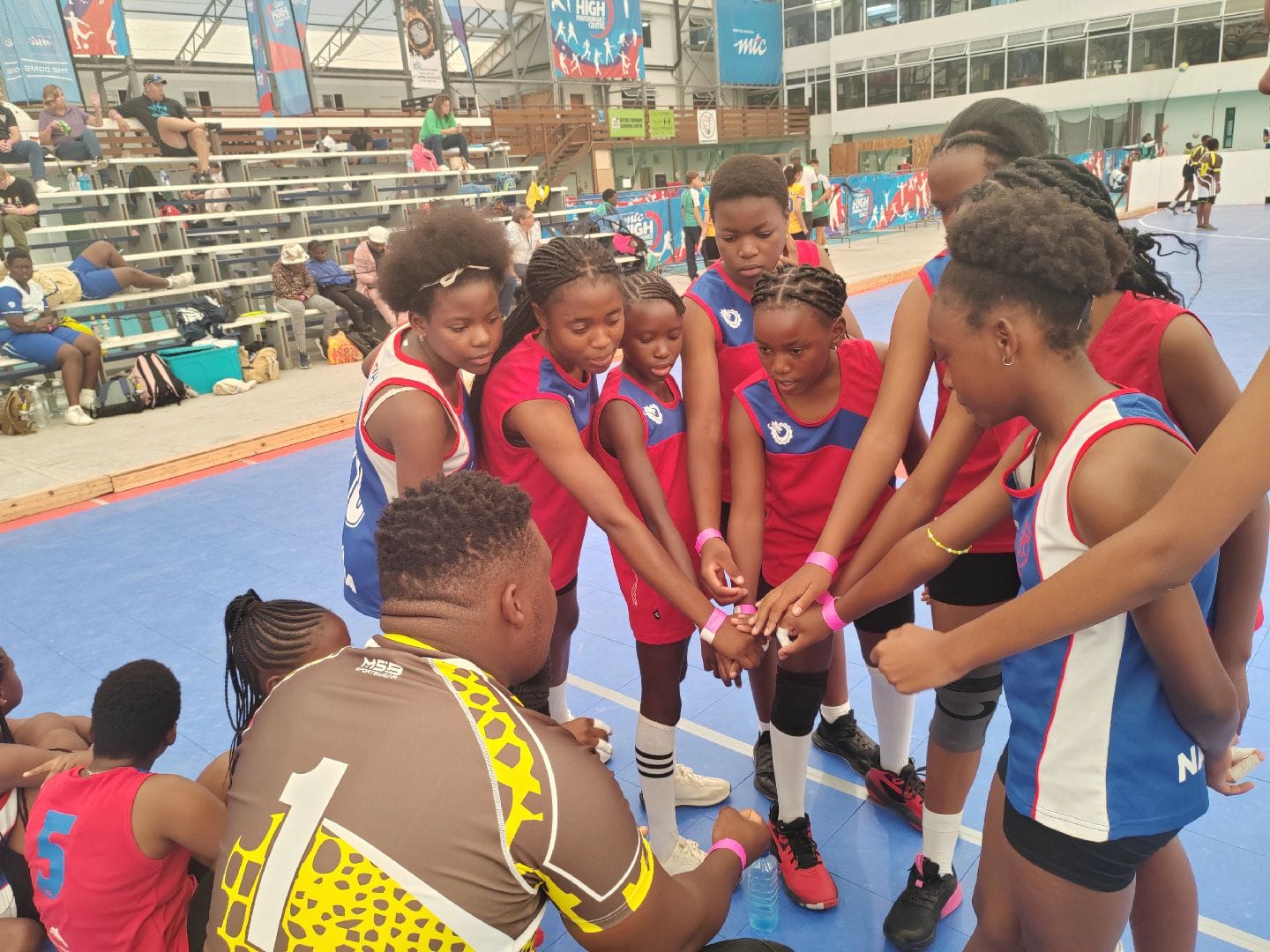 Volleyball players gathered in a team huddle