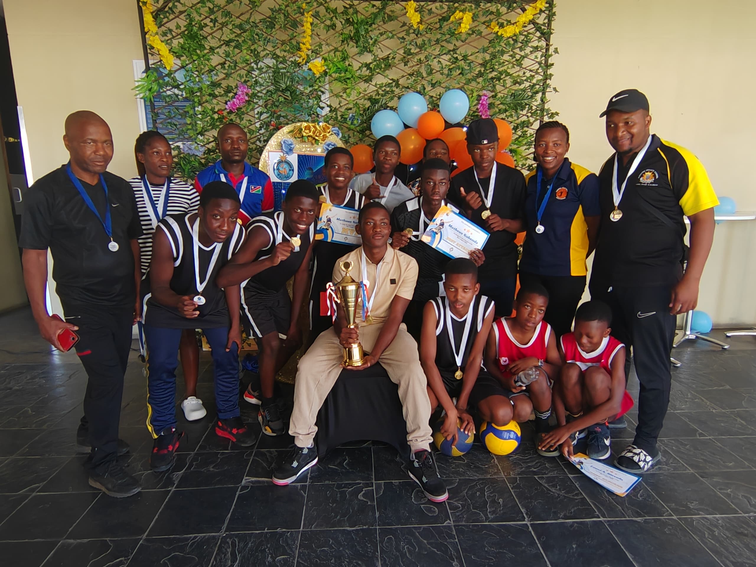 Volleyball team celebrating together with medals